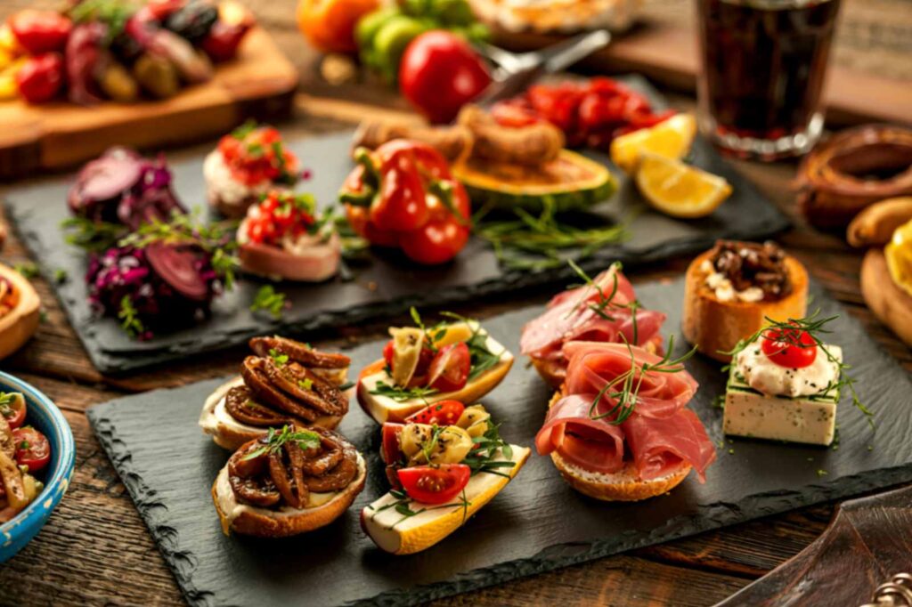 Trays of tapas with Spanish tortilla, croquetas, jamón, and olives served at a bar in Madrid. Guests at La Esperanza Granada can also enjoy a similar experience in Granada.