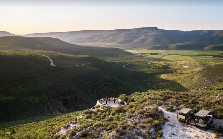 Luxury safari landscape at Bushmans Kloof Wilderness Reserve in South Africa, featuring dramatic sandstone cliffs, vast green plains, and pristine natural scenery in the Cederberg Mountains.