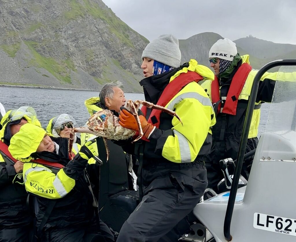 Fishermen hauling a heavy cage of live Norwegian King Crabs from the Barents Sea