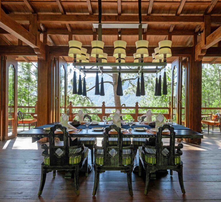 Luxurious dining room framed by timber beams and forest views at a five-star resort in Bhutan — showcasing the natural elegance and design of the best hotels and resorts in the world.