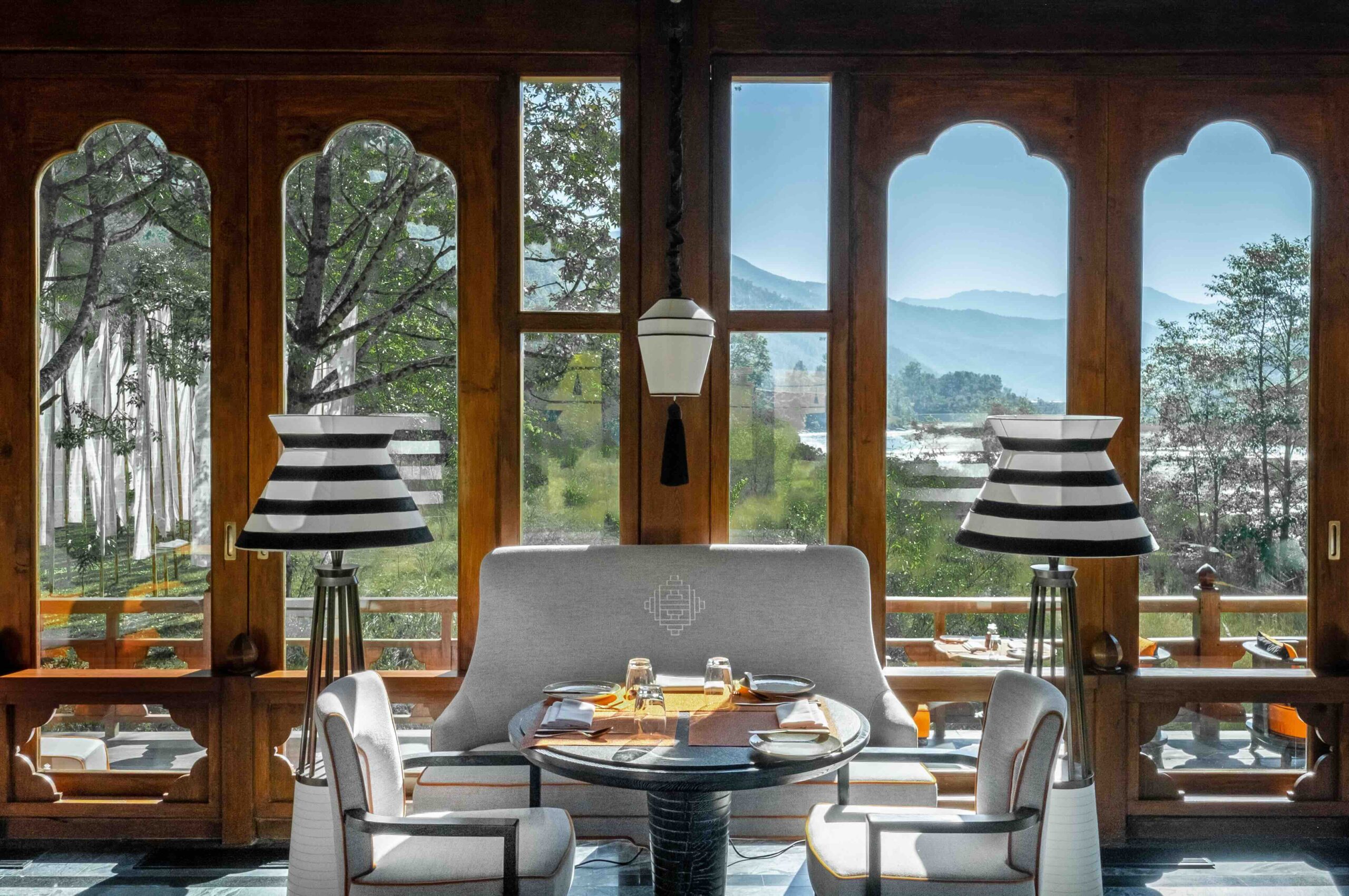 Elegant breakfast setting at a luxury hotel in Bhutan, featuring panoramic mountain views through traditional Bhutanese windows — part of Travelife Magazine’s curated list of the best hotels and resorts in the world.