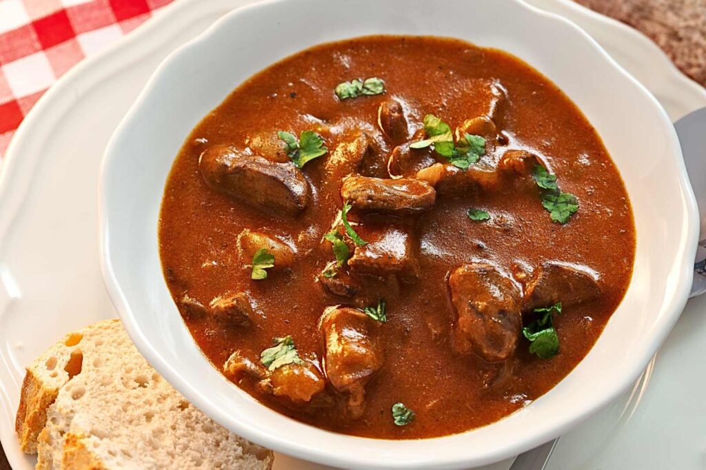 Traditional Hungarian cuisine — hearty gulyás soup with bread on the side.