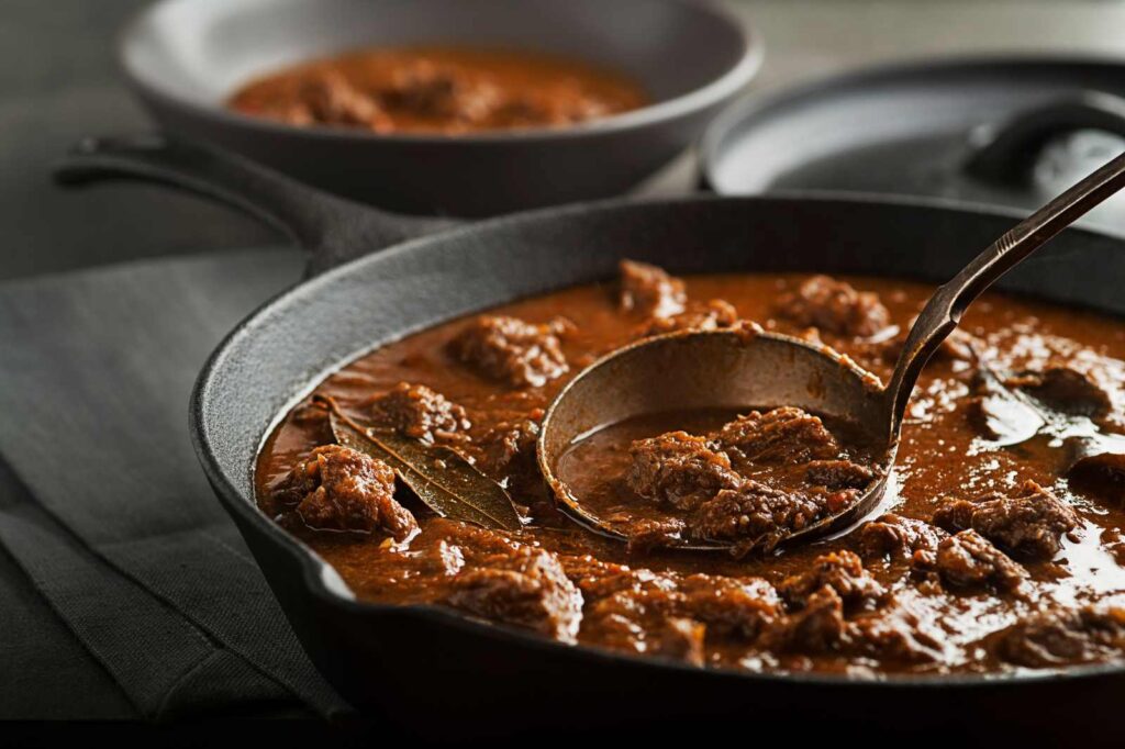 Traditional Hungarian cuisine — hearty goulash soup served in a cast-iron pan.