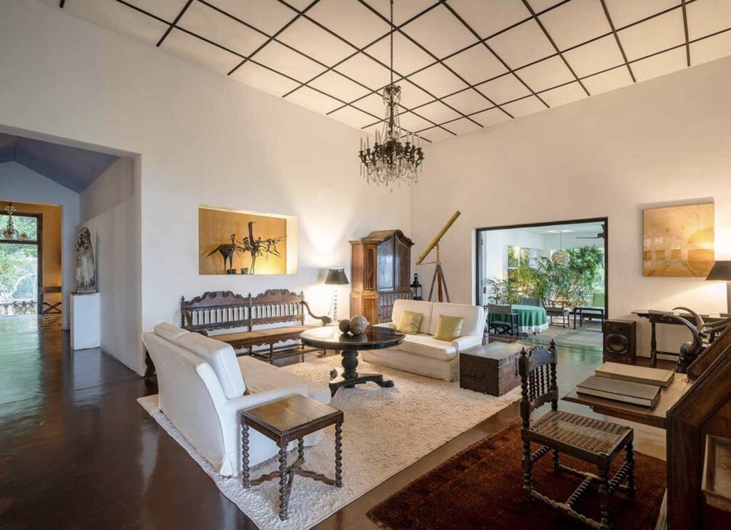 Living room of Lunuganga, home of architect Geoffrey Bawa in Sri Lanka, featuring Sri Lankan antiques, eclectic artworks, sculptural accents, and vintage curios.
