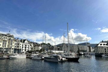 Fishing boats and historic waterfront along Ålesund’s harbor, Norway — coastal architecture and fjord scenery.