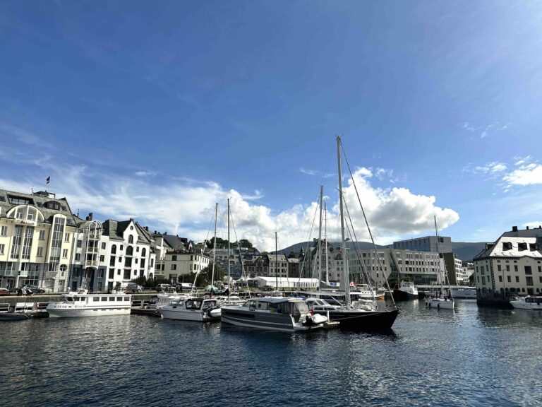 Fishing boats and historic waterfront along Ålesund’s harbor, Norway — coastal architecture and fjord scenery.