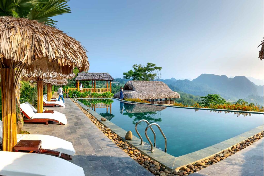 Lush Asian hotel garden with vibrant tropical greenery, shaded walking paths, and curated landscaping designed for relaxation at a luxury resort.