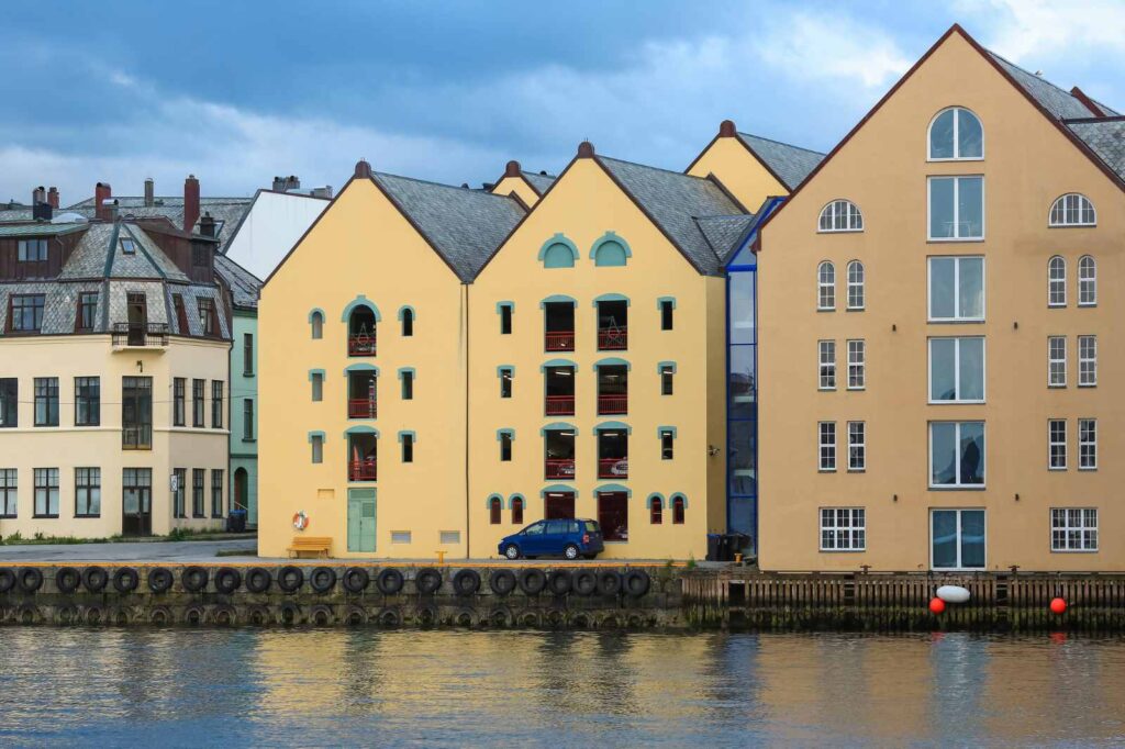 Pastel colored buildings line the waterfront of the Art Nouveau city of Alesund in Northern Norway, one of the gateways to the famous Norwegian fjords.