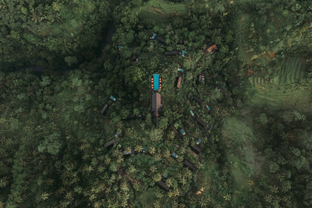 Aerial view of Buahan, a Banyan Tree Escape in Bali, showing luxury glamping villas hidden within tropical rainforest in the Payangan Highlands near Ubud