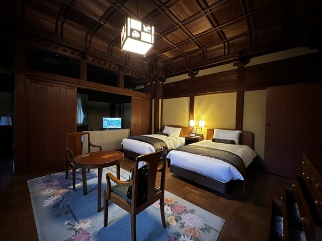 Guest room in the heritage wing of Fujiya Hotel Hakone featuring exposed timber beams, traditional architecture, and classic furnishings