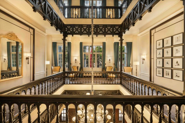 Historic French colonial courtyard at Sofitel Legend Metropole Hanoi featuring elegant balconies, warm lighting, and classic architecture