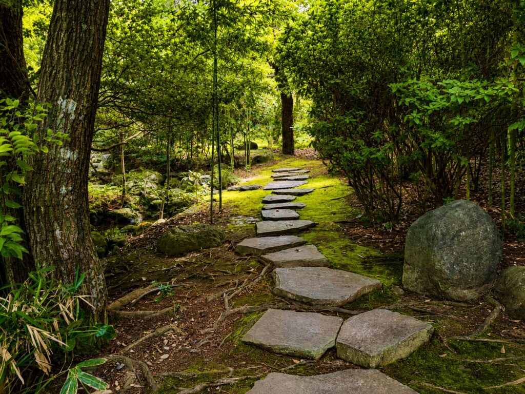 Ancient moss-covered stone pathway through the historic gardens of Numazu Club, a Michelin One-Key luxury ryokan in Shizuoka, Japan. Photographed by Travelife Magazine.