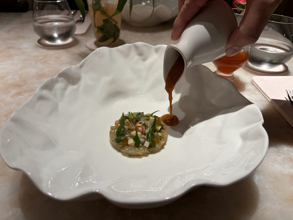Sauce being poured over a contemporary Thai fine-dining course at Baan Phraya, Mandarin Oriental, Bangkok.