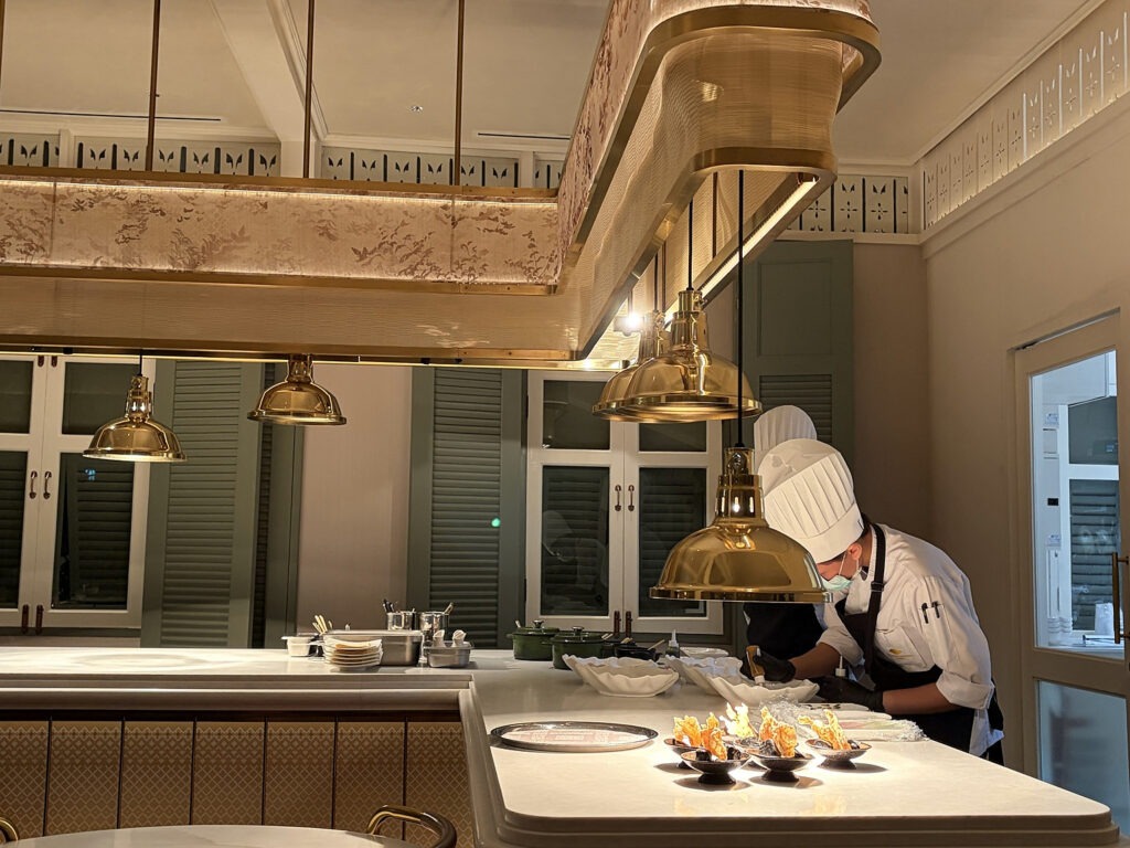 Chef preparing a tasting-menu course in the open kitchen at Baan Phraya, Mandarin Oriental, Bangkok.