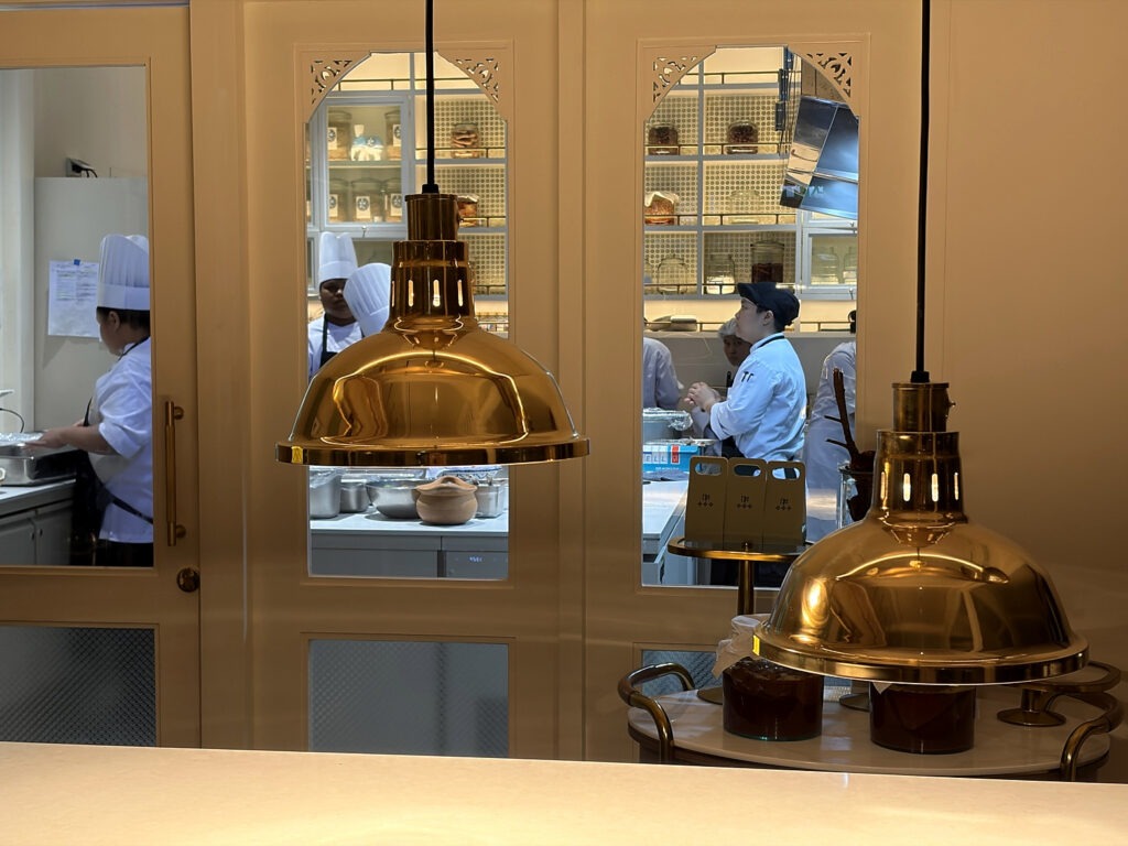 Open kitchen with brass pendant lamps at Baan Phraya, the Thai fine-dining restaurant at Mandarin Oriental, Bangkok.