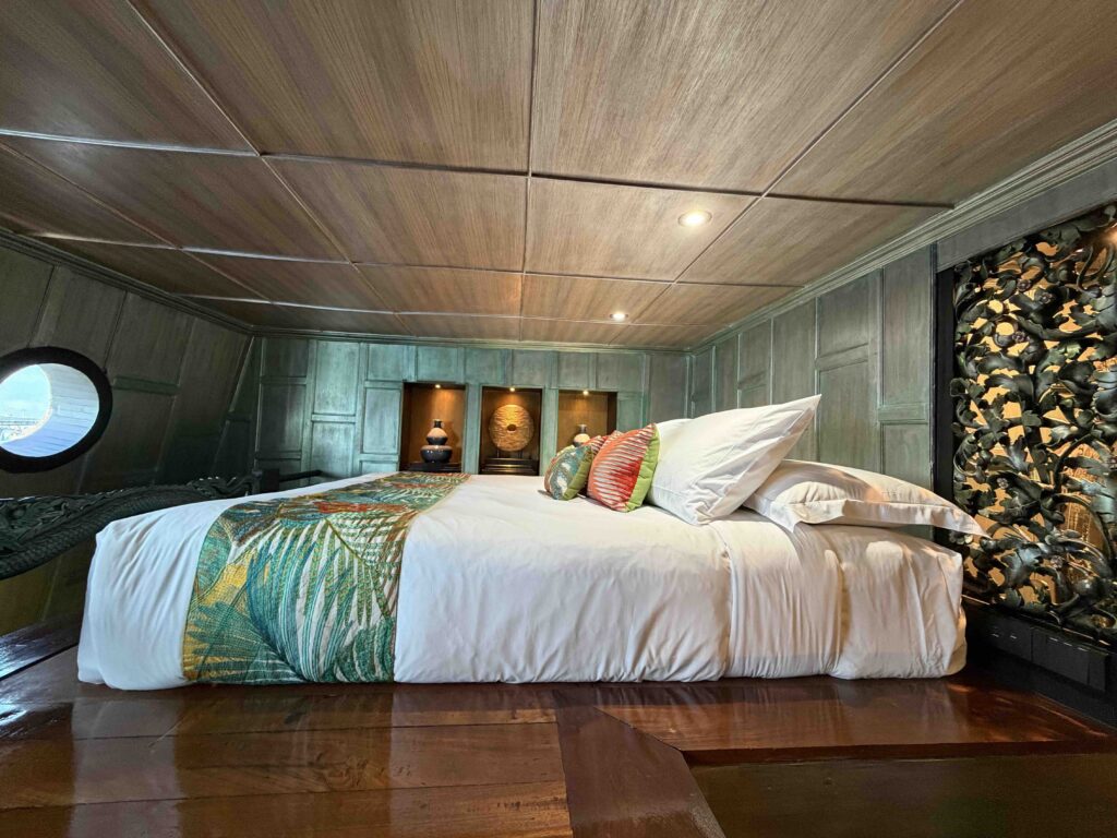 Raised Thai-style bed in the master stateroom aboard Loy Dream, the restored rice barge of Anantara Hotels and Loy Pela Voyages
