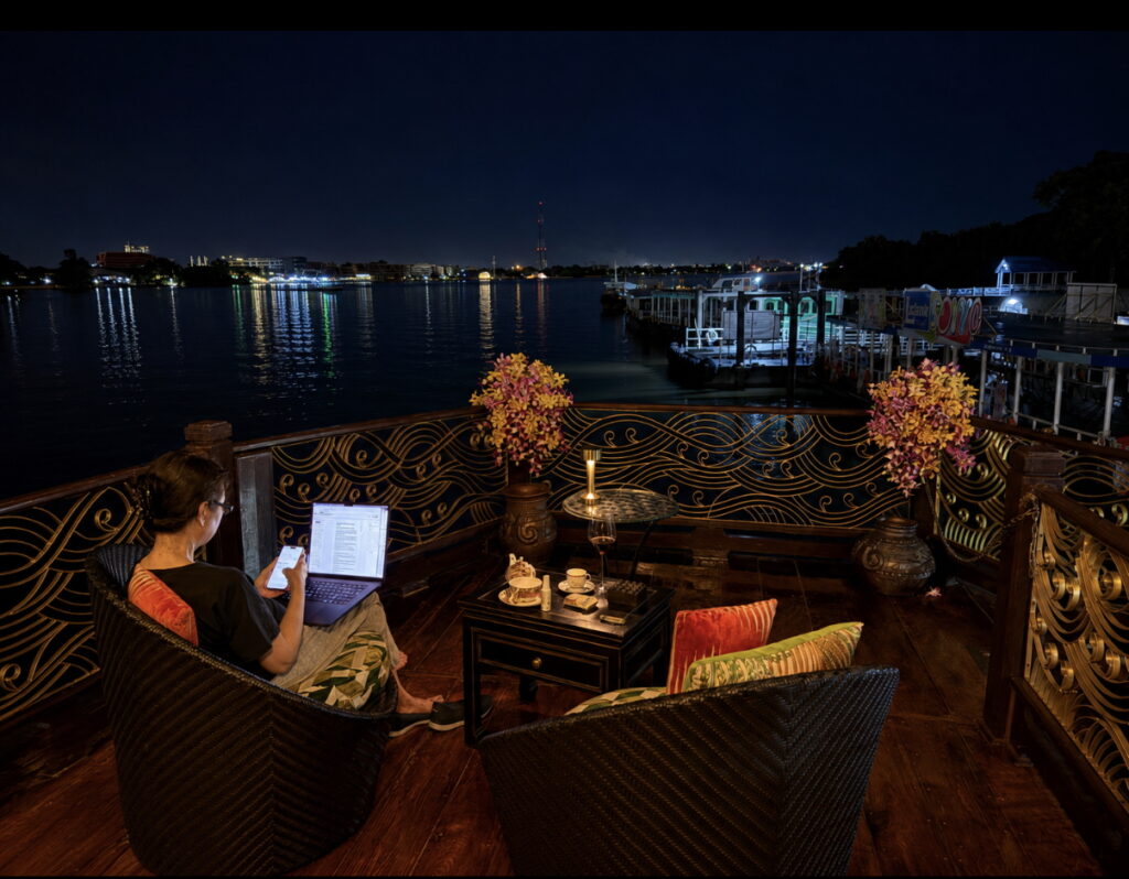 Loy Dream’s upper deck lounge illuminated at night during an Anantara Chao Phraya River cruise