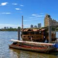 Loy Dream, Anantara’s restored Thai rice barge, cruising the Chao Phraya River in Bangkok