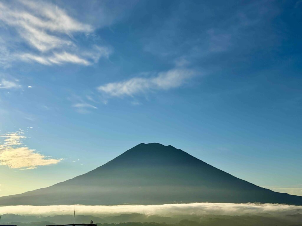Mount Yotei near Niseko, Hokkaido, Japan, with its distinctive volcanic peak rising beneath a blue sky with scattered clouds.