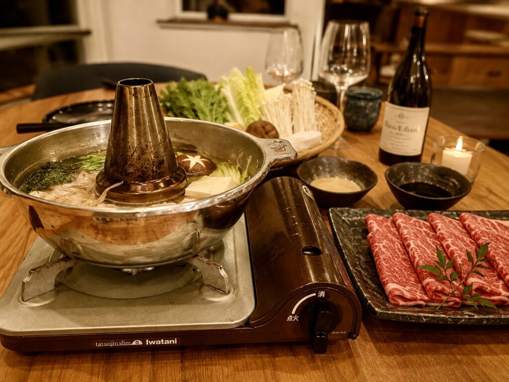 Thinly sliced Hokkaido beef beside a Japanese shabu-shabu hot pot, prepared for a private dinner at Soga Forest Chalet in Niseko, Japan.